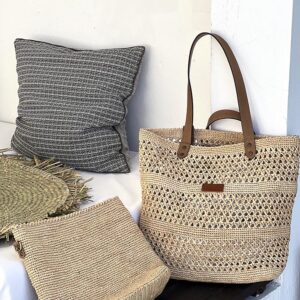 Photo d'un sac en raphia naturel posé à côté d'un canapé, point au crochet motif petits trous, devant le sac est posé une pochette en raphia, fait main, couleur naturelle, doublée en tissu coton imprimé, même point motif petits trous que le sac, deux produits complémentaires.