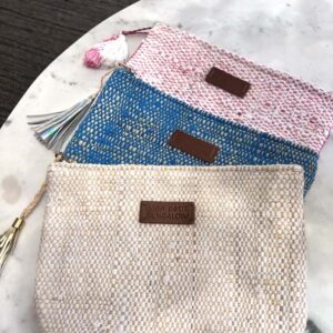 Photo de trois pochettes SAMARA en tissage traditionnel raphia et coton, 3 coloris : blanc, fuschia et turquoise. Petite pochette multi usage, pratique pour emmener partout, dans un sac à main. Idéale pour les petites affaires de voyage. Style bohème.