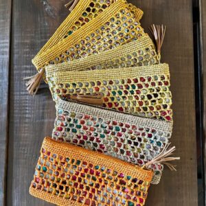 Photo de pochettes en raphia GIPSY, plusieurs coloris naturel, thé, rose pâle, jaune clair et jaune poussin, doublé tissu imprimé, artisanat de Madagascar. Style bohème.