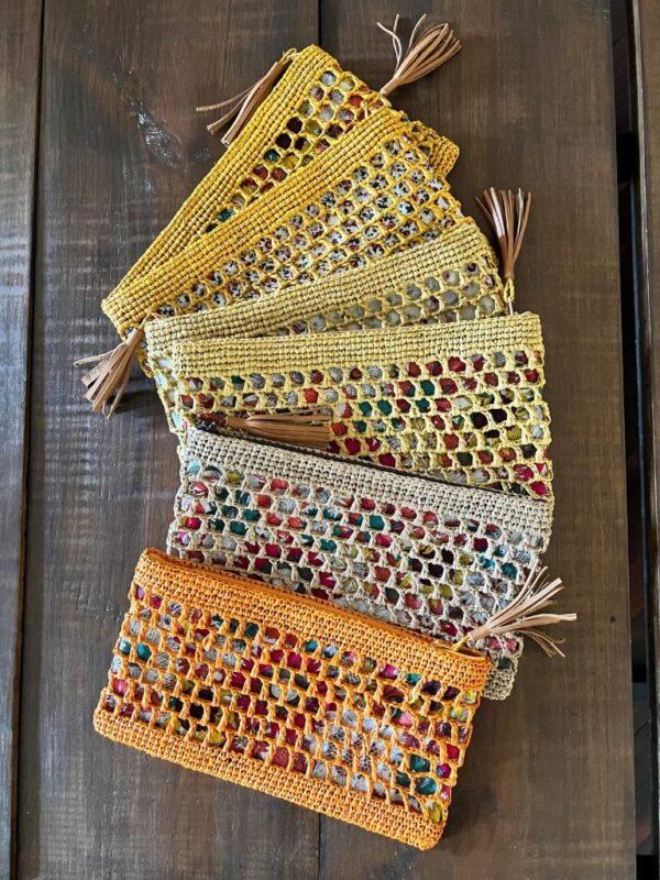 Photo de pochettes en raphia GIPSY, plusieurs coloris naturel, thé, rose pâle, jaune clair et jaune poussin, doublé tissu imprimé, artisanat de Madagascar. Style bohème.